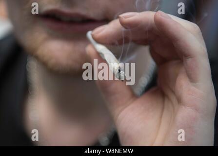 Berlin, Deutschland. 10 Aug, 2019. Eine gemeinsame geräuchert am Rande der 23 Hanfparade für die Legalisierung von Cannabis. Quelle: Jörg Carstensen/dpa/Alamy leben Nachrichten Stockfoto