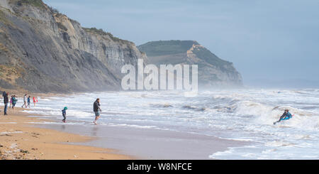 Charmouth, Dorset, Großbritannien. 10. August 2019. UK Wetter: Urlauber heraus auf einem blustery Tag am Meer Dorf Charmouth als ungewöhnlich starke süd-westliche Winde weiter an der Südwestküste am Samstag Nachmittag zu zerschlagen. Die stürmischen Bedingungen nicht abschrecken fossilen Jäger auf Charmouth Beach. Credit: Celia McMahon/Alamy Leben Nachrichten. Stockfoto