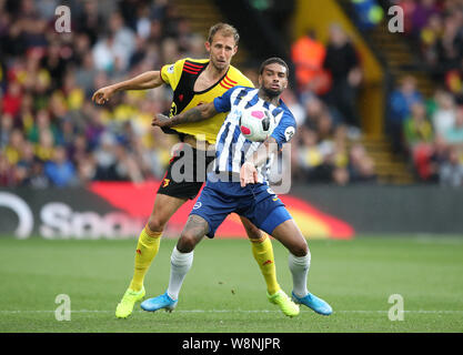 Die watford Craig Dawson (links) und Brighton und Hove Albion Jurgen Locadia Kampf um den Ball während der Premier League Match an der Vicarage Road, Watford. Stockfoto