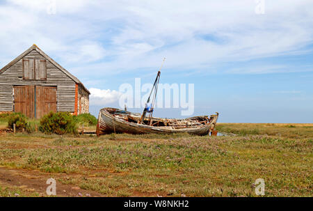 Eine alte Verschlechterung der Boot am Kai von der Kohle Scheune am North Norfolk Hafen von Thornham, Norfolk, England, Vereinigtes Königreich, Europa. Stockfoto