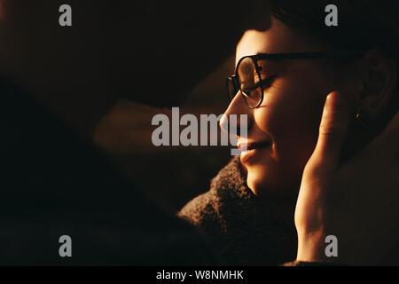 Anonyme Kerl sanft berühren Gesicht der schönen Frau in stilvollen Gläsern. unkenntlich Mann berühren Gesicht der Freundin Stockfoto