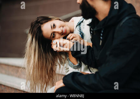 Schöne Frau Streicheln mit Erntegut bärtiger Mann sitzen zusammen auf Schritte auf der Straße Stockfoto