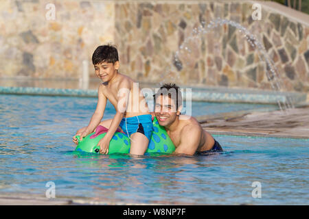 Vater und Sohn spielt in einem Schwimmbad Stockfoto