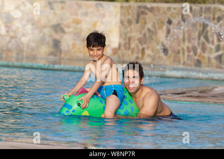 Vater und Sohn spielt in einem Schwimmbad Stockfoto