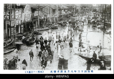 [1910s Japan - Kanto Flut in Tokio, 1910] - honjo Hitotsume-dori in Tokio während der Flut vom 11. August 1910 (Meiji 43). Dies ist eine Katastrophe, jetzt bekannt als die Kanto Flut (関東大水害, Kanto Dai Suigai). Es war die dritte Tokio schlimmsten Flutkatastrophe des 20. Jahrhunderts. 20. jahrhundert alte Ansichtskarte. Stockfoto