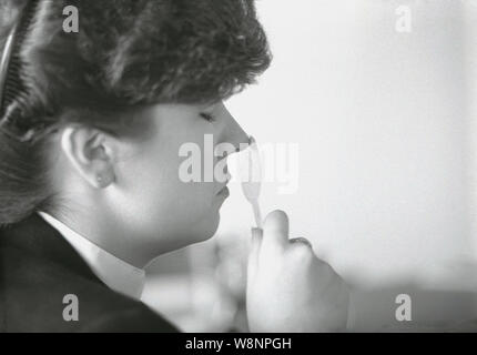 1980 s, historische, eine Dame mit einem Duft strip vor ihrer Nase, Prüfung Duftstoffe, England, UK. Stockfoto