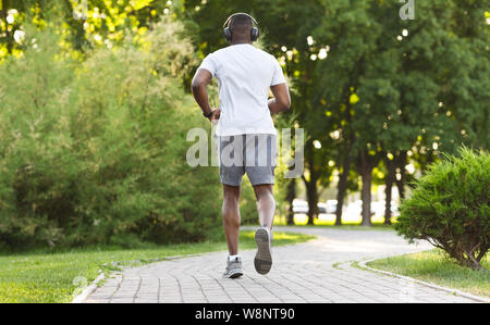 Athletische afrikanische amerikanische Mann laufen entlang der Park Trail Stockfoto