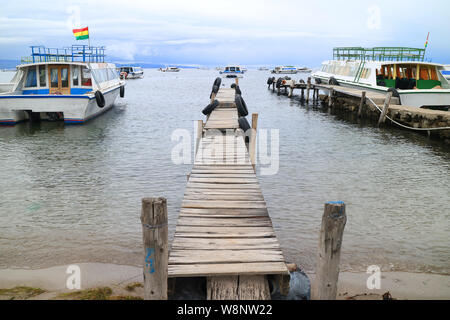 Holz- Docks durch die Boote zur Isla Del Sol umgeben auf dem Titicacasee in der Stadt an der Copacabana, Bolivien, Südamerika Stockfoto