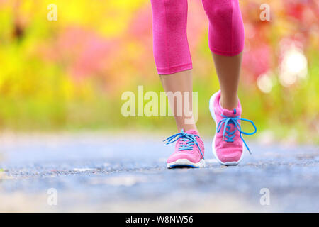 Wandern und Joggen Frau mit athletische Beine und Schuhe. Frauen gehen auf Trail im Wald im gesunden Lebensstil Konzept mit Nahaufnahme auf die Laufschuhe. Weibliche Athleten jogger Training im Freien. Stockfoto