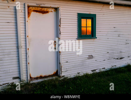 WA 17275-00 ... WASHINGTON - Sonnenuntergang spiegelt sich im Fenster der Gebäude am Punkt Wilson Leuchtturm im Fort Warden State Park, Port Townsend. Stockfoto