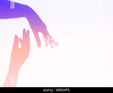 Neon getönt. Die beiden Frauen Hände für jedes andere erreichen. Helfende Hand Silhouette, weiblichen und männlichen zusammen. Stockfoto