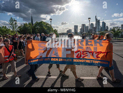 07 März 2017, Hessen, Frankfurt/Main: Teilnehmer einer Demonstration des "eebrücke Frankfurt" mit der Inschrift icherer Hafen jetzt 'Gehe mit einem Banner über eine Brücke. Die Seebrücke ist eine bundesweite Bewegung meer Retter im Mittelmeer zu unterstützen. Aufgrund eines Abseilen action, Schifffahrt auf dem Main Zuvor vorübergehend ausgesetzt. Foto: Frank Rumpenhorst/dpa Stockfoto