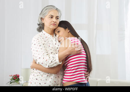 Junge Frau umarmt ihre Mutter Stockfoto