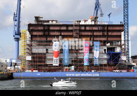 10. August 2019, Mecklenburg-Vorpommern, Rostock: Im Dock der Warnemünde Werft in MV Werften der 216 Meter langen mittleren Abschnitt der globale Klasse Kreuzfahrtschiff ist im Bau. Das Schiff ist über 342 Meter lang, 54 Meter breit und 60 Meter hoch mit 20 Etagen vom Kiel bis zu den Schornstein zu sein. Wie das Unternehmen mitteilte, ist das größte Kreuzfahrtschiff der Welt. Foto: Bernd Wüstneck/dpa-Zentralbild/dpa Stockfoto