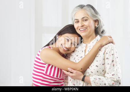 Junge Frau umarmt ihre Mutter