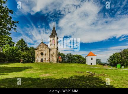 Krasikov, Kokasice/Tschechische Republik - 9. August 2019: Blick auf die Kirche von Maria Magdalena und einem Glockenturm. Sonnigen Sommertag mit blauen Himmel und Wolken. Stockfoto