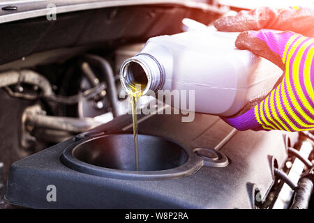 Wechseln Sie das Öl. Hand Mechaniker in der Reparatur von Autos. In der Nähe von Öl für den Motor. Motor Öl gießen zu Auto Motor. Auftanken und füllen Sie Öl in den engin Stockfoto