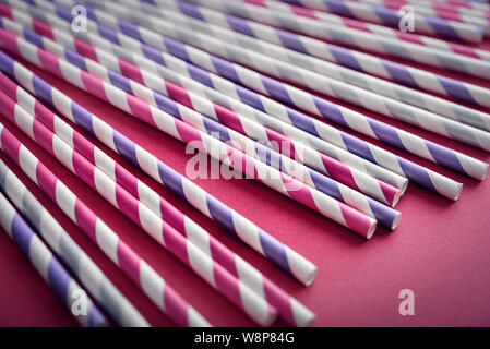Bunte trinken gestreifte Trinkhalme auf rosa Hintergrund closeup Stockfoto