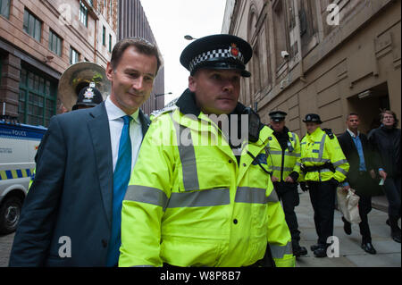 Manchester, Großbritannien. 7. Oktober 2015. Der Minister für Gesundheit Jeremy Hunt hatte, die von der Polizei als Angry anti-Sparmaßnahmen und anti-fracking Demonstrant begleitet werden Stockfoto