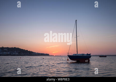 Boote in einem ruhigen Meer bei Sonnenuntergang an instow Beach North Devon UK gegen Appledore Stockfoto