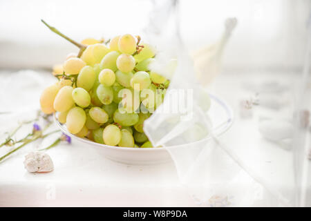 Reif grün Pinsel der Trauben in eine Platte auf der Fensterbank. Stockfoto