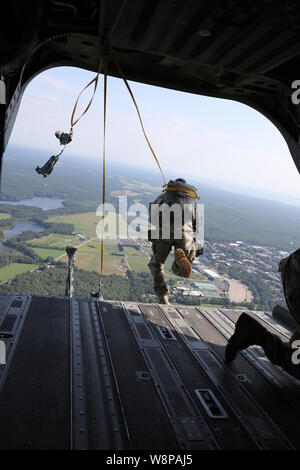 Eine zerstreute Soldat die Teilnahme an der Internationalen Leapfest Airborne Wettbewerb in South Kingstown, Rhode Island gibt es eine CH-47 von Soldaten aus Bravo Company der New York Army National Guard, 3.BATAILLON, 126 Luftfahrt von 1.500 Fuß in der Luft überschrift für sein Ziel geflogen. Soldaten aus Bravo Company, 3.BATAILLON, 126 Luftfahrt, in Rochester, New York, haben die Unterstützung, um Leapfest Wettbewerb der Rhode Island National Guard seit 2011. (U.S. Army National Guard Foto von Sgt. Andrew Winchell) Stockfoto