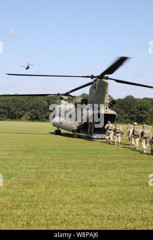 Airborne Soldaten an der Internationalen Leapfest Airborne Wettbewerb in South Kingstown, Rhode Island geben Sie einen CH-47 von Soldaten aus Bravo Company der New York Army National Guard, 3.BATAILLON, 126 Aviation geflogen. Soldaten aus Bravo Company, 3.BATAILLON, 126 Luftfahrt, in Rochester, New York, haben die Unterstützung, um Leapfest Wettbewerb der Rhode Island National Guard seit 2011. (U.S. Army National Guard Foto von Sgt. Andrew Winchell) Stockfoto