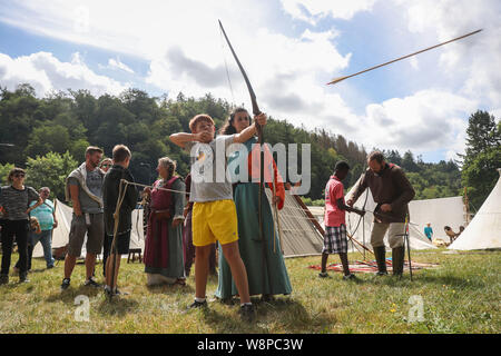 Bouillon, Belgien. 10 Aug, 2019. Ein Junge schießt einen Pfeil während der jährlichen Mittelalter Festival in der Stadt Bouillon in Belgien, 10.08.2019. Die jährlichen Mittelalter Festival in Bouillon am Samstag begann, mit zeigt, kämpft und das Handwerk von mittelalterlichen Stil Touristen, die bis in das Mittelalter zurück. Credit: Zheng Huansong/Xinhua/Alamy leben Nachrichten Stockfoto