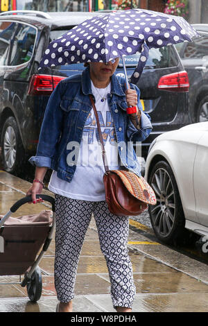 London, Großbritannien. 10 Aug, 2019. Ist eine Frau unter einem Schirm gesehen während einer kurzen Regen in London. Quelle: Steve Taylor/SOPA Images/ZUMA Draht/Alamy leben Nachrichten Stockfoto