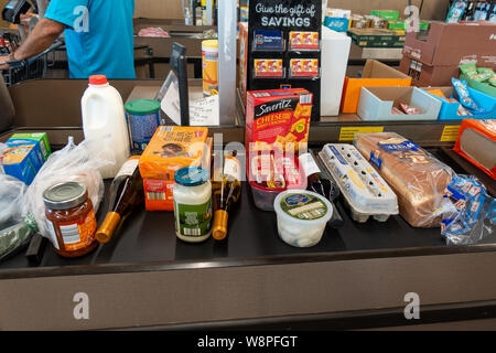 Ft. Pierce, FL/USA -810/19: Eine Übersicht über die Lebensmittel auf einem Förderband gesäumt am Check out-Zähler von Aldi zu speichern. Stockfoto