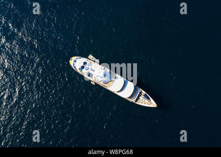 Ansicht von oben, beeindruckende Luftaufnahme einer luxuriösen Yacht segeln auf blauem Meer. Emerald Küste (Costa Smeralda) Sardinien, Italien. Stockfoto