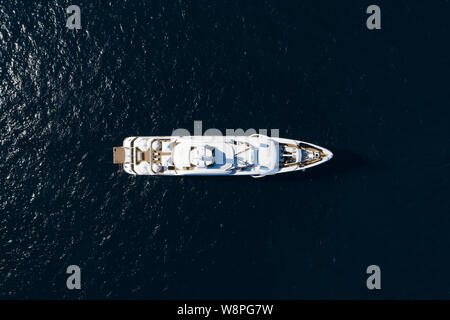 Ansicht von oben, beeindruckende Luftaufnahme einer luxuriösen Yacht segeln auf blauem Meer. Emerald Küste (Costa Smeralda) Sardinien, Italien. Stockfoto