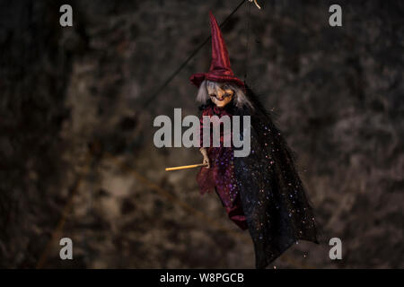 Hexe mit Besen und Hut hängen an der Decke. Halloween Dekoration Stockfoto