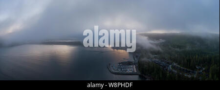 Antenne Panoramablick auf einen kleinen abgelegenen Stadt an der Pazifik Küste während eine trübe Sommer Sonnenaufgang. In Port Renfrew, Vancouver Island, BC, Stockfoto