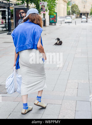 SKOPJE/Mazedonien - 27. AUGUST 2018: Frau im Baseball Cap geht eine Straße in Skopje City Center. Stockfoto