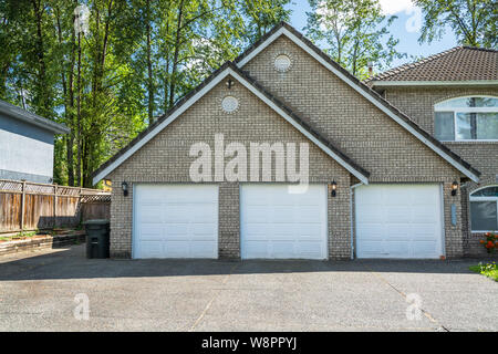 Garage von großen Wohnhaus mit drei Parkplätze und drei Türen Stockfoto