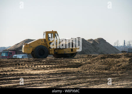 Schwere Maschinen arbeiten auf der Autobahn Baustelle. Bulldozer, Kipper, Boden Verdichter und Vibrationswalze Stockfoto