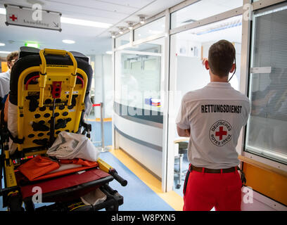 Nürnberg, Deutschland. 30. Juli, 2019. Ein Mitglied des Rettungsdienstes 'Deutsches Rotes Kreuz' (Deutsches Rotes Kreuz) ist an der Rezeption in der Zentralen Notaufnahme im Klinikum Nürnberg Süd. Mit einem Durchschnitt von 250 Patienten pro Tag, die Notaufnahme des Klinikums Nürnberg Standorte gehören zu den größten in Deutschland. (Dpa-Korr: "zwischen Leben und Tod - eine Nacht in der Notaufnahme") Credit: Daniel Karmann/dpa/Alamy leben Nachrichten Stockfoto