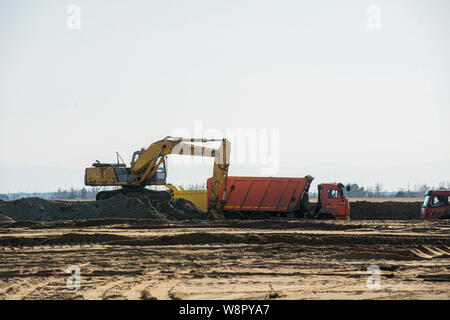 Bagger laden der Erde, dem Sand in einem Dump Truck. Stockfoto