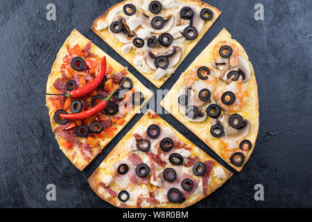 Sortierte Pizza Scheiben. Margherita, Salami, vier Käse Pizza. Ansicht von oben. Verschiedene Arten von Pizza auf die texturierte alten Holztisch Stockfoto