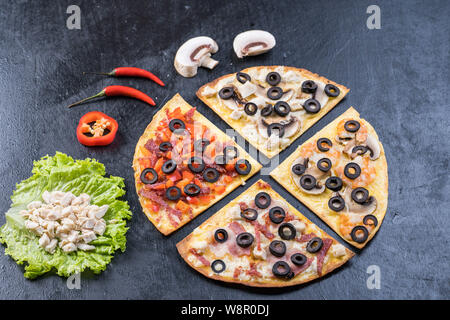 Sortierte Pizza Scheiben. Margherita, Salami, vier Käse Pizza. Ansicht von oben. Verschiedene Arten von Pizza auf die texturierte alten Holztisch Stockfoto