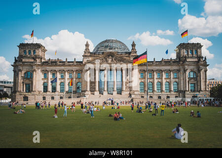 Berlin, Deutschland - August 2019: Viele Menschen auf der Wiese vor dem Reichstagsgebäude (Deutscher Bundestag), ein Wahrzeichen an einem sonnigen Sommertag Stockfoto