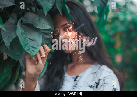 Ein Mädchen spielen mit Wunderkerzen. Stockfoto