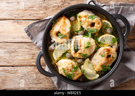 Griechische Küche cod Steaks mit Zitronen und Oliven closeup in einer Pfanne auf dem Tisch. horizontal oben Ansicht von oben Stockfoto