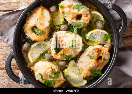 Würzige cod Steaks gebackene mit Zitronen und Oliven closeup in einer Pfanne auf dem Tisch. horizontal oben Ansicht von oben Stockfoto