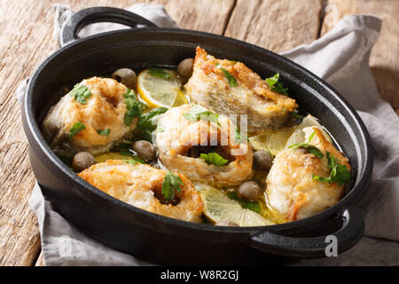 Gebackener Kabeljau Fisch mit Zitronen und Oliven in pikanter Soße close-up in einer Pfanne auf dem Tisch. Horizontale Stockfoto