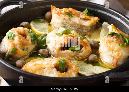 Würzige cod Steaks gebackene mit Zitronen und Oliven closeup in einer Pfanne auf dem Tisch. Horizontale Stockfoto