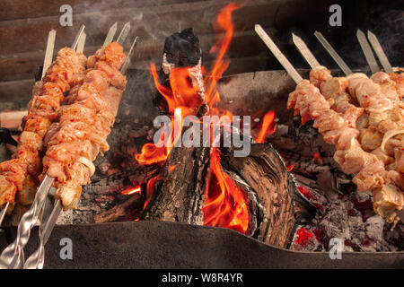 Fleischspieße grillen. Schwein oder Rind sind auf offenem Feuer gebraten. Grill Küche party close-up-Bild. Kebab oder schaschlik Kochen auf spuckt. Stockfoto