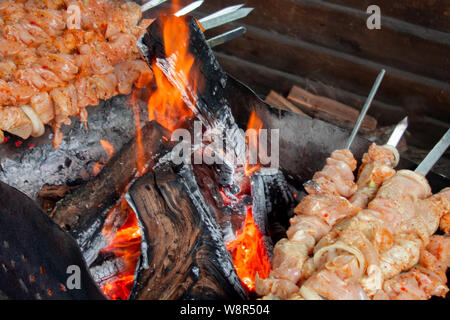 Fleischspieße grillen. Schwein oder Rind sind auf offenem Feuer gebraten. Grill Küche party close-up-Bild. Kebab oder schaschlik Kochen auf spuckt. Stockfoto