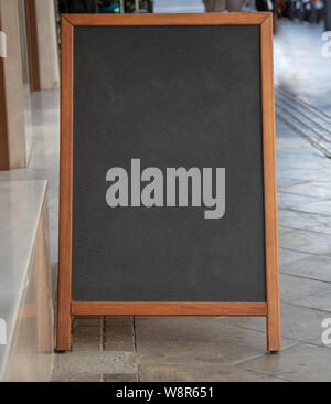 Blackboard leer mit Holzrahmen im Freien stehend auf einem Bürgersteig. Menü mockup Vorlage Stockfoto
